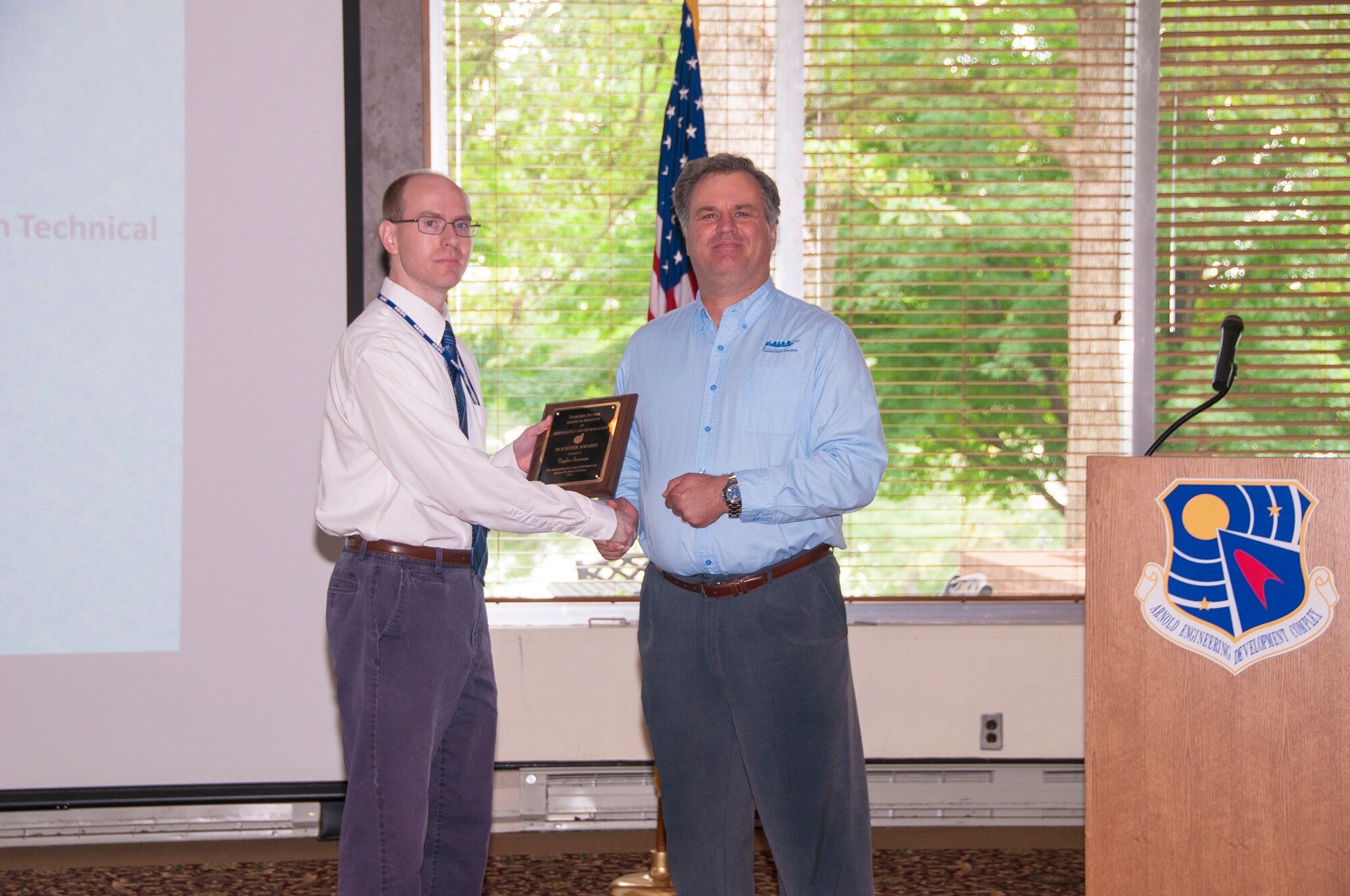 Dr. Taylor Swanson (left), with AEDC, receives an AIAA Booster Award from Dr. Joe Sheeley, with AEDC and AIAA Tennessee Section Chair, for outstanding first year performance as Section Technical Director. (U.S. Air Force photos/Holly Peterson)

