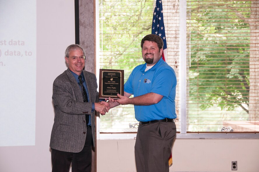 Andrew Hughes (right), with AEDC, receives the AIAA Billy J. Griffith Engineering Analysis Award from Dr. Joe Wehrmeyer, AEDC, for outstanding analysis support, using ground test and Computational Fluid Dynamics data, to the fifth Generation Aerial Target test program. (U.S. Air Force photos/Holly Peterson)