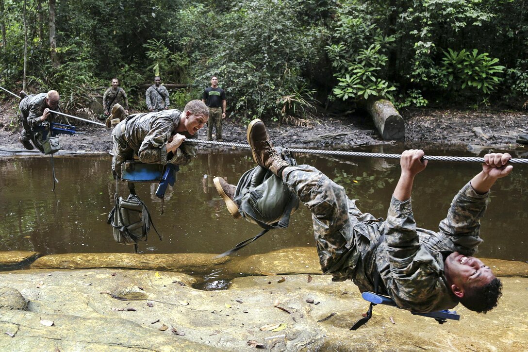 U.S. soldiers maneuver across a wire cable over a river during a team obstacle course event at the French jungle warfare school in Gabon, France, June 10, 2016. Army photo by Spc. Yvette Zabala-Garriga 