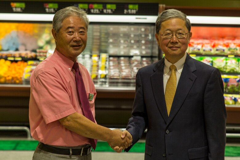 Buddie Kolath, store director, left, and Joseph H. Jeu, director and CEO of the Defense Commissary Agency, shake hands during the grand opening ceremony for the new commissary on Marine Corps Air Station Iwakuni, Japan, June 21, 2016. Designed to anticipate and meet the needs of shoppers, the new grocery store is approximately 50 percent larger, with 52,710 total square feet and is located between the Kintai Inn and Kawashimo housing area.  The new store features three additional checkout stands, a 22,000 square foot sales floor and an assortment of approximately 10,000 items. (U.S. Marine Corps photo by Lance Cpl. Aaron Henson/Released)