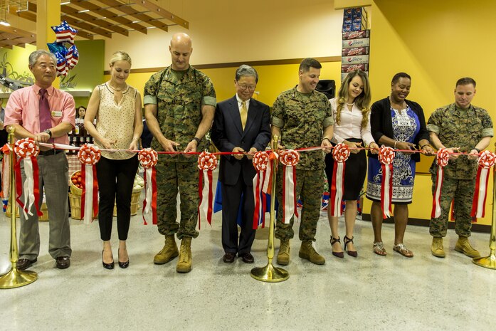 From left to right, Buddie Kolath, store director, Kim Shipley, a station resident, U.S. Marine Corps Col. Daniel Shipley, Marine Aircraft Group 12 commanding officer, Joseph H. Jeu, director and CEO of the Defense Commissary Agency, U.S. Marine Corps Col. Robert V. Boucher, station commanding officer, Marcela Londono and Carla Bates, station residents, and U.S. Marine Corps Sgt. Maj. Christopher Garza, station sergeant major, conduct the ribbon-cutting ceremony during the grand opening of the new commissary at Marine Corps Air Station Iwakuni, Japan, June 21, 2016. Designed to anticipate and meet the needs of shoppers, the new grocery store is approximately 50 percent larger, with 52,710 total square feet and is located between the Kintai Inn and Kawashimo housing area. (U.S. Marine Corps photo by Lance Cpl. Aaron Henson/Released)