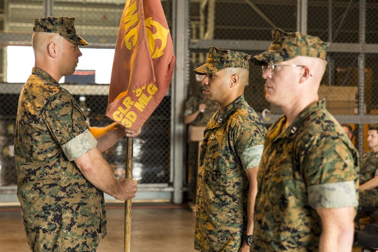 U.S. Marine Corps Master Sgt. Anthony Bowers, company first sergeant with Combat Logistics Company 36, left, passes the company guidon to Capt. Roderick Singleton Jr., outbound CLC-36 commanding officer, during a change of command ceremony at Marine Corps Air Station Iwakuni, Japan, June 20, 2016. Singleton relinquished his authority to Capt. William Sanford, incoming CLC-36 commanding officer. This ceremony symbolizes the end of Singleton’s tour after assuming the role as commanding officer of CLC-36 in July 2013. (U.S. Marine Corps photo by Lance Cpl. Aaron Henson/Released) 