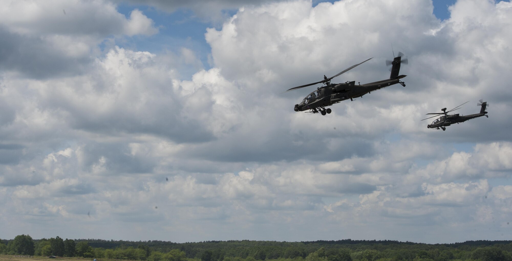 Two AH-64 Apache attack helicopters fly over a live-fire range during Exercise Anakonda 2016 June 16, 2016, in Poland. The event was an opportunity for U.S. Airmen to train alongside allies and test aircraft, vehicles and other equipment in a live-fire exercise. The event served as a wrap up for Anakonda 2016, a Polish-led international exercise that aimed to train, exercise and integrate Poland and its allied forces by demonstrating their defense capabilities to deploy in mass numbers and sustain combat power. (U.S. Air Force photo/Airman 1st Class Lane T. Plummer)