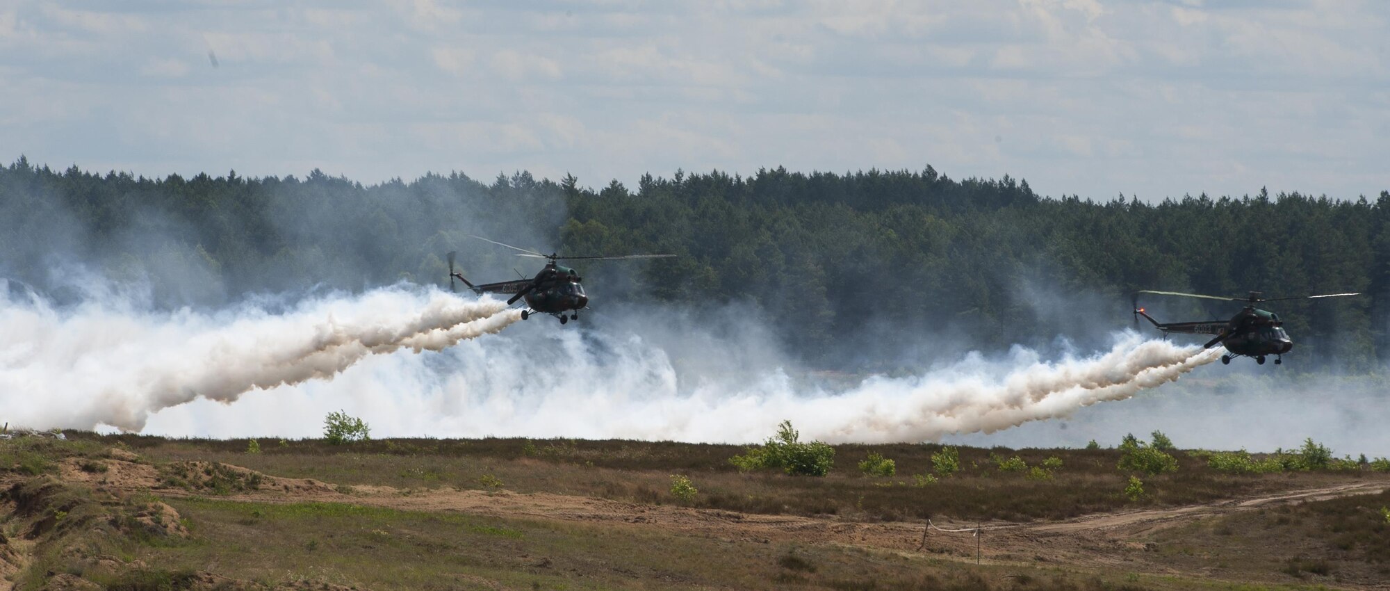 Two helicopters fly over a live-fire range during exercise Anakonda 2016 June 16, 2016, in Poland. The event was an opportunity for U.S. Airmen to train alongside allies and test aircraft, vehicles and other equipment in a live-fire exercise. The event served as a wrap up for Anakonda 2016, a Polish-led international exercise that aimed to train, exercise and integrate Poland and its allied forces by demonstrating their defense capabilities to deploy in mass numbers and sustain combat power. (U.S. Air Force photo/Airman 1st Class Lane T. Plummer)