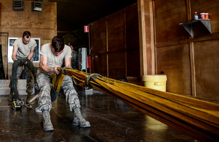 Tech. Sgt. Wesley Vinson, 379th Expeditionary Operations Support Squadron aircrew flight equipment NCO in charge, pulls a drag parachute in preparation of packing it for a B-5 Stratofortress June 15, 2016, at Al Udeid Air Base, Qatar. A drag chute is used to decelerate the B-52 during landing, reducing wear and tear to ceramic brake pads used by the aircraft, increasing their life span. The 379th EOSS AFE flight is the focal point for all flight equipment in regards to inspection, maintenance and repacking of all aircraft-related survival equipment. (U.S. Air Force photo/Senior Airman Janelle Patiño/Released)