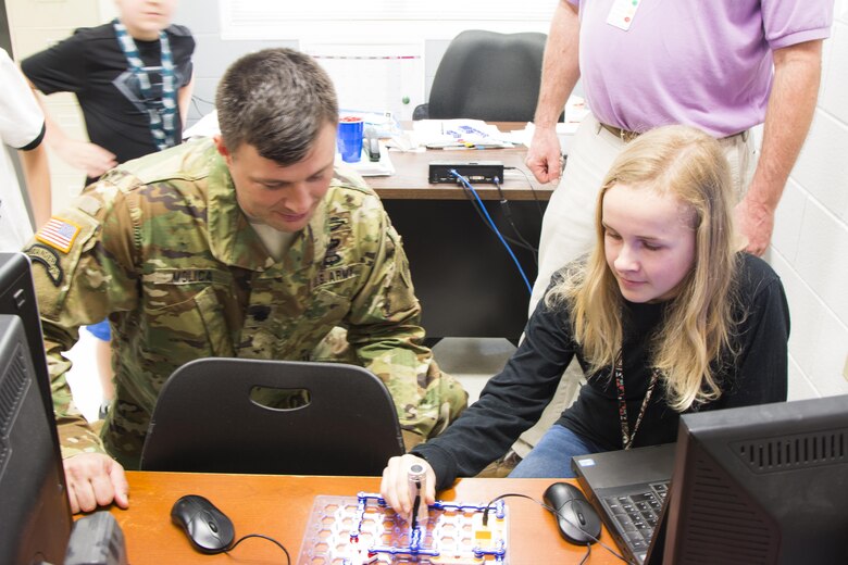 Lt. Col. Nathan Molica, deputy commander, participated in the Charleston Metro Chamber of Commerce's Principal for a Day program where he shadowed the principal of Cario Middle School to learn about their STEM program. Here, he learns about nigh light circuitry from one of their students.