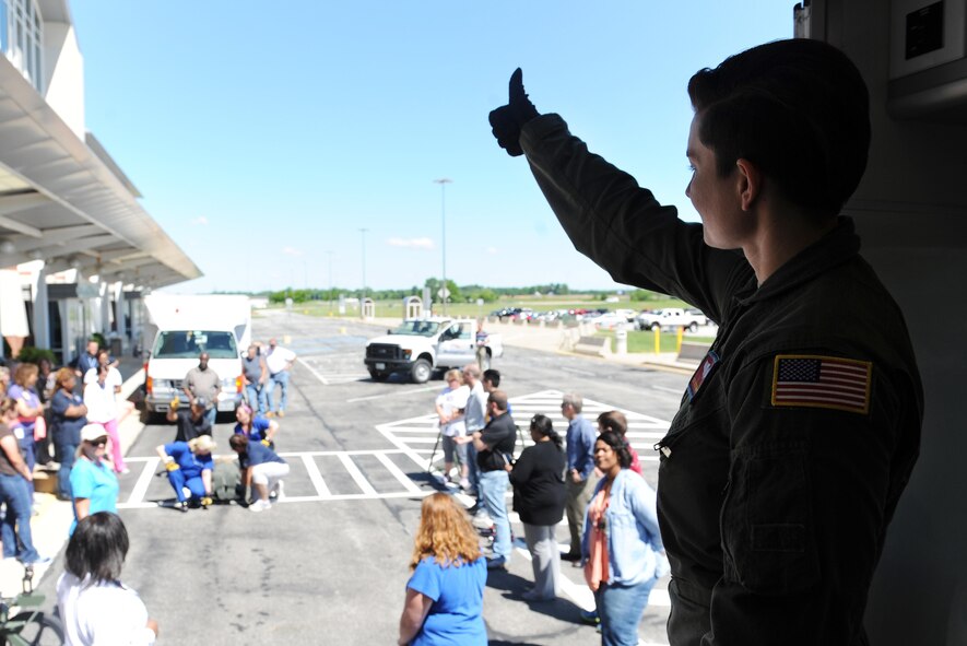 Staff Sgt. Dasha Ermanova, right, 375th AES aeromedical evacuation technician, signals to the litter carriers that they can now bring the "patient" onto the vehicle during training June 7, 2016 at the MidAmerica St. Louis Airport in Mascoutah, Illinois. 375th AES servicemembers worked with U.S. Department of Veterans Affairs personnel, teaching them how to transfer a patient on and off an aircraft safely. Since the DVA works with military entities during natural disasters and other emergency situations, the training will familiarize the civilians on how the equipment the military uses. (U.S. Air Force photo by Staff Sgt. Maria Bowman)