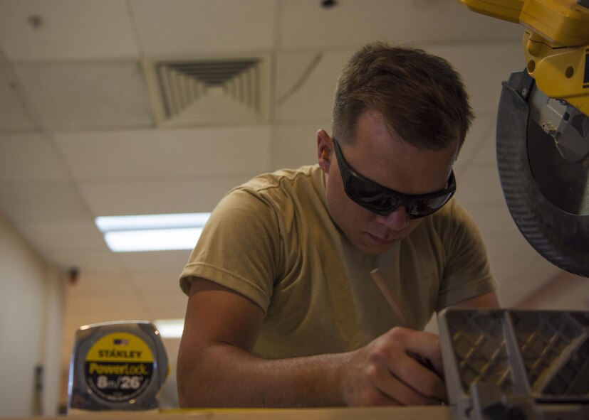 Senior Airman Eric Woolston, 455th Expeditionary Civil Engineer Squadron structural journeyman, marks a two by four to be used in the constructing of a wall in the 455th Air Expeditionary Wing Headquarters building, June 20, 2016, Bagram Airfield, Afghanistan. Structural specialists have a varied skill set that is used along with specialized materials, and equipment to build numerous structures that range from locker rooms to improvised emergency disaster relief shelters. (U.S. Air Force photo by Senior Airman Justyn M. Freeman)