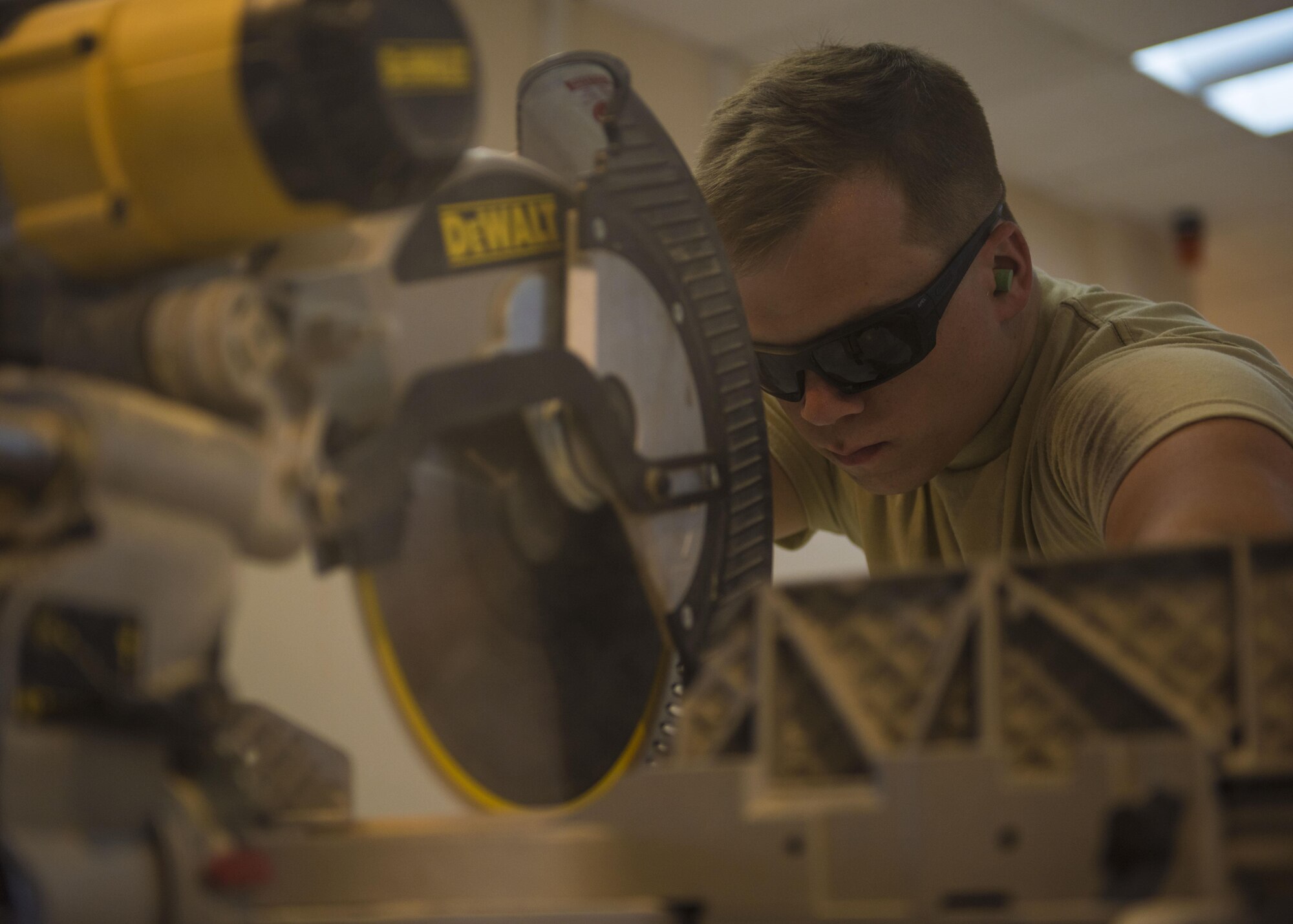 Senior Airman Eric Woolston, 455th Expeditionary Civil Engineer Squadron structural journeyman, cuts a two by four to the correct size while constructing a wall, June 20, 2016, Bagram Airfield, Afghanistan. Members of the structures flight are building the wall as part of an ongoing renovation project. (U.S. Air Force photo by Senior Airman Justyn M. Freeman)