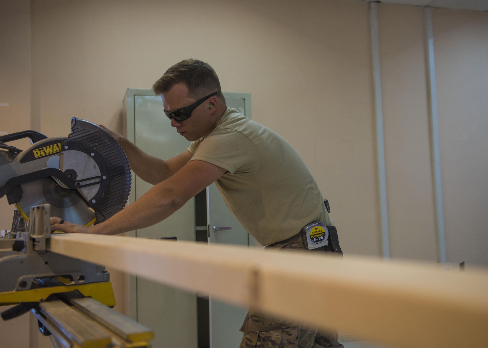 Senior Airman Eric Woolston, 455th Expeditionary Civil Engineer Squadron structural journeyman, cuts a two by four to be used as wood studs for a wall, June 20, 2016, Bagram Airfield, Afghanistan. Wood studs are used for the foundation of the wall and anchoring them into concrete. (U.S. Air Force photo by Senior Airman Justyn M. Freeman)