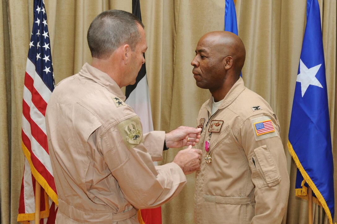 Maj. Gen. Scott Kindsvater, 9th Air Expeditionary Task Force-Levant commander, pins the Legion of Merit medal on Col. Clarence Lukes Jr., 386th Air Expeditionary Wing outgoing commander, during a change of command ceremony at an undisclosed location in Southwest Asia, June 20, 2016. Over the past year the 386 AEW has grown to be the largest intelligence, surveillance, and reconnaissance operation in the entire world with 35 dedicated assets. (U.S. Air Force photo by Senior Airman Zachary Kee)