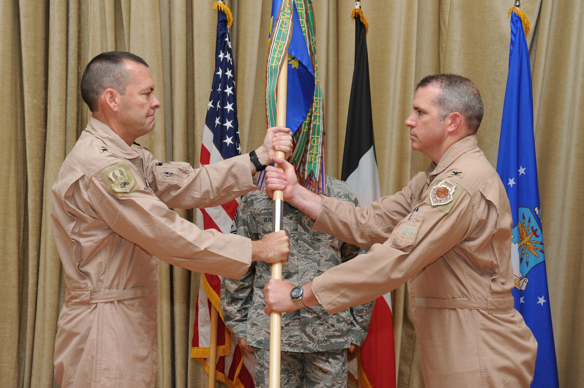 Col. Charles Bolton, 386th Air Expeditionary Wing commander, receives the guidon from Maj. Gen. Scott Kindsvater, 9th Air Expeditionary Task Force-Levant commander, during a change of command ceremony at an undisclosed location in Southwest Asia, June 20, 2016. Bolton assumed command after serving as the 314th Operations Group commander at Little Rock Air Force Base, Arkansas. (U.S. Air Force photo by Senior Airman Zachary Kee)