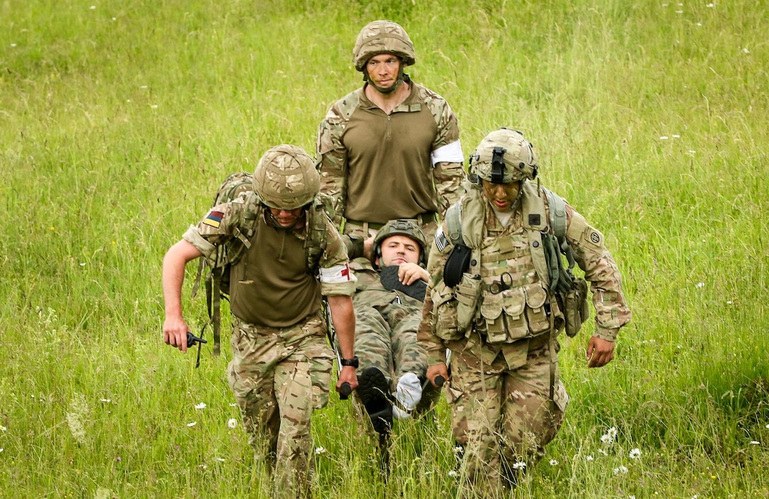 U.S. and British soldiers carry a Polish paratrooper suffering from a simulated ankle injury off the drop zone after an airborne operation during Swift Response16 in Hohenfels, Germany, June 15, 2016. Army photo by Sgt. Juan F. Jimenez
