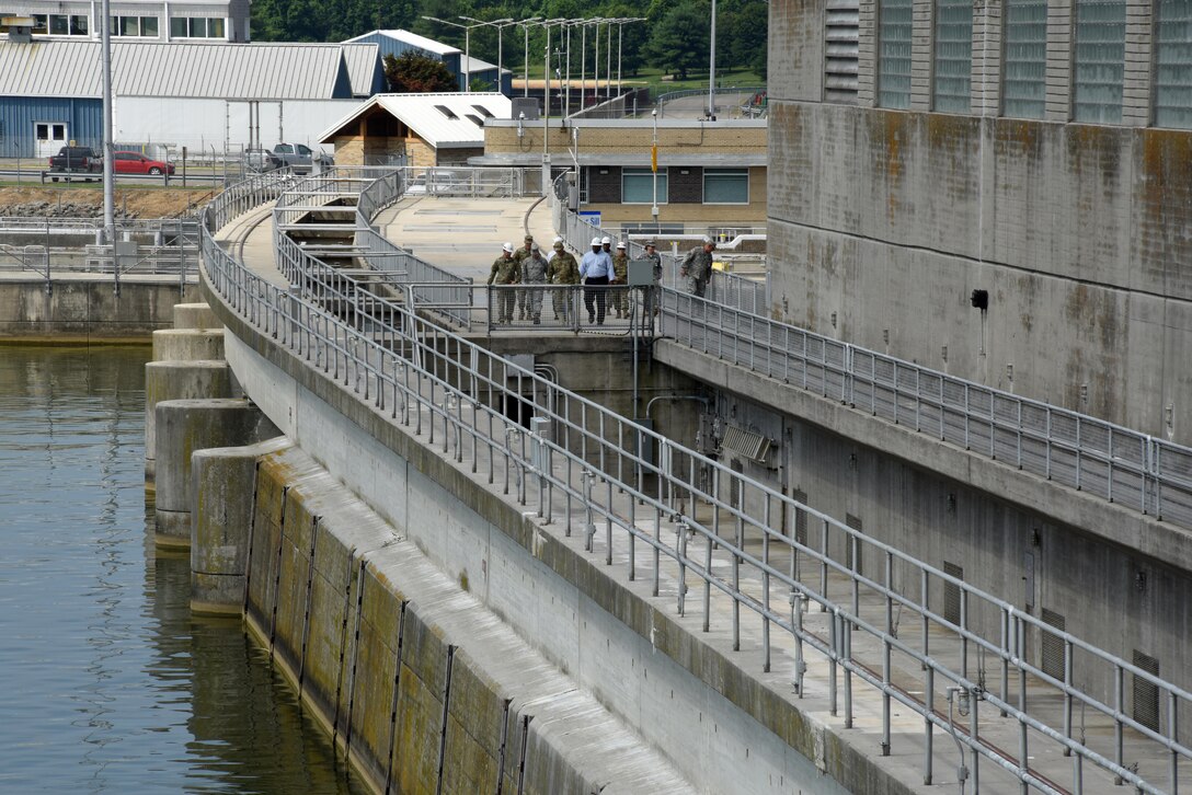 Corps of Engineers and Tennessee National Guard officials escort Maj. Gen. Jeffrey H. Holmes, deputy adjutant general for the Tennessee National Guard, across Old Hickory Dam during a site visit to the facility during a security assistance exercise in Hendersonville, Tenn., June 20, 2016.  The general visited soldiers participating in the exercise and received an update from the platoon leader in charge of protecting the power plant and switchyard.