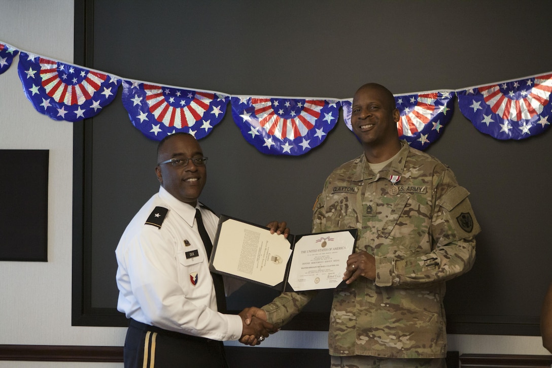 DLA Distribution commander Army Brig. Gen. Richard Dix, left, presents Master Sgt. Michael J. Clayton with the Defense Meritorious Service Award.