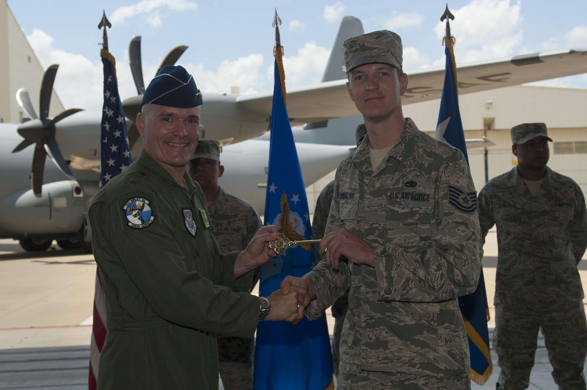 U.S. Air Force Gen. Carlton D. Everhart II, Air Mobility Command commander, presents a ceremonial C-130J key to U.S. Air Force Tech. Sgt. James Kowalski, 19th Aircraft Maintenance Squadron C-130J crew chief, June 20, 2016, at Little Rock Air Force Base, Ark. The final C-130J completed the H-model to J-model transition for the 19th Airlift Wing’s fleet. (U.S. Air Force photo/Senior Airman Harry Brexel)
