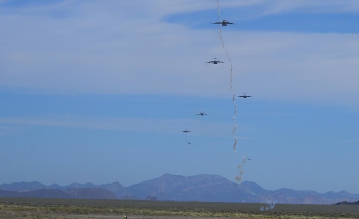 Multiple C-130 Hercules, assigned to the 29th Weapons Squadron, Little Rock Air Force Base, Arkansas, fly in formation over the Nevada Test and Training Range as a flare is shot during the Joint Forcible Entry Exercise portion of the United States Air Force Weapons School Advanced Integration, June 16, 2016. Joint Forcible Entry was an exercise that tested the Air Force's capability for tactical airlift. (U.S. Air Force photo by Airman 1st Class Kevin Tanenbaum)
