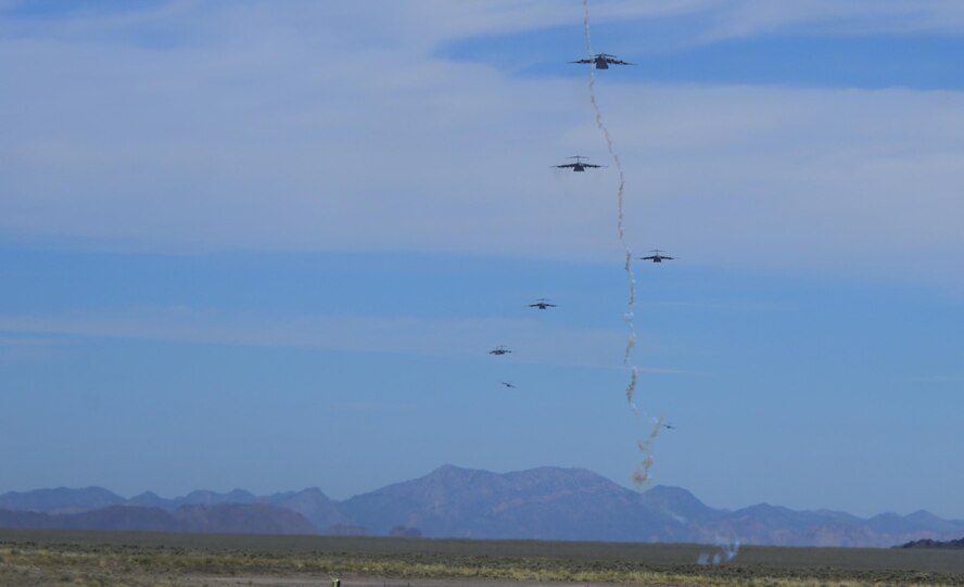 Multiple C-130 Hercules, assigned to the 29th Weapons Squadron, Little Rock Air Force Base, Arkansas, fly in formation over the Nevada Test and Training Range as a flare is shot during the Joint Forcible Entry Exercise portion of the United States Air Force Weapons School Advanced Integration, June 16, 2016. Joint Forcible Entry was an exercise that tested the Air Force's capability for tactical airlift. (U.S. Air Force photo by Airman 1st Class Kevin Tanenbaum)
