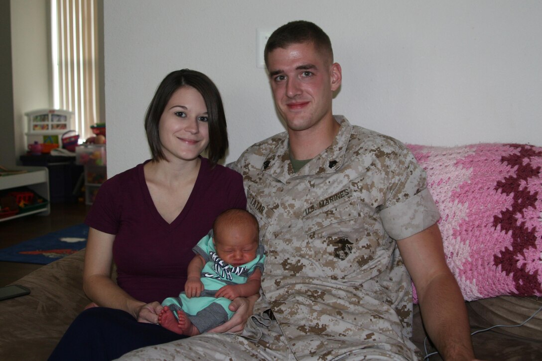 Sgt. Matthew Tatar and his wife Tiffany in their home with their two-week-old baby boy, who was born May 31 in front seat of their minivan on Purvis Road aboard Marine Corps Base Quantico.