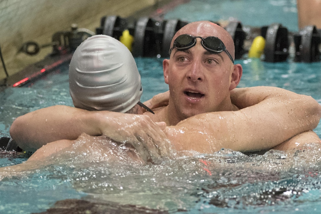 Army veteran Sean Walsh, left, a U.S. Special Operations Command team member, hugs Marine Corps Staff Sgt. Matthew Branch after their 50-meter freestyle event during the 2016 Department of Defense Warrior Games at the U.S. Military Academy in West Point, N.Y., June 20, 2016. DoD photo by Roger Wollenberg