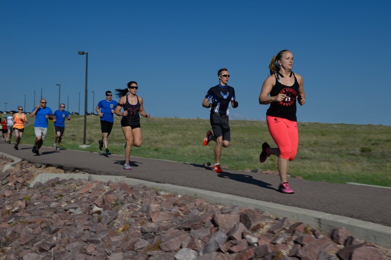 Participants run down the running path during the first run of the 12th annual duathlon at Schriever Air Force Base, Colorado, Friday, June 17, 2016. The event required all 22 participants to complete a 1-mile run, followed by a 12-mile bike ride and finish with another 1-mile run. (U.S. Air Force photo/Christopher DeWitt)