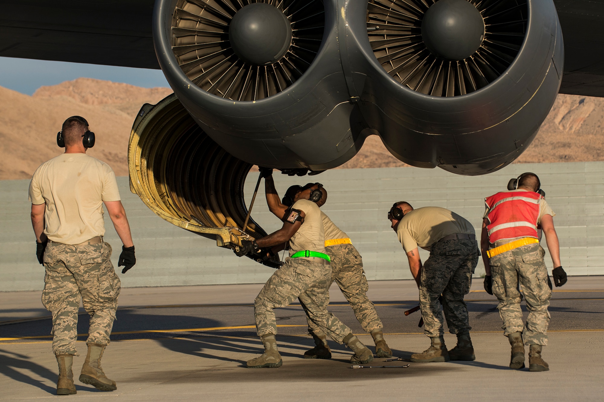 A group of U.S. Air Force Airmen work together to close an engine cowling on a B-52H Stratofortress prior to a mission on June 8, 2016, Nellis Air Force Base, Nev. The Airmen are among 45 Active Duty and Air Force Reserve maintenance personnel on temporary duty at Nellis in support of the 340th Weapons Squadron. (U.S. Air Force photo by Master Sgt. Greg Steele/Released)