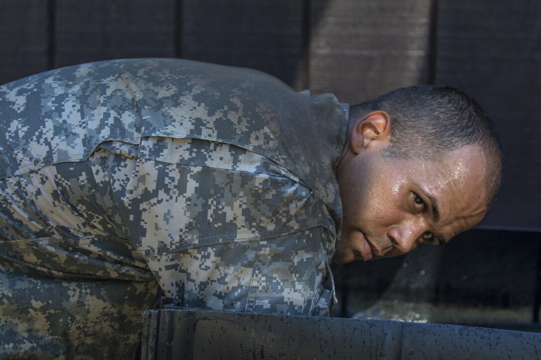 A Drill sergeant candidate at the United States Army Drill Sergeant Academy located at Fort Jackson, S.C., takes a moment to cool down in the arms immersion water tank after completing the fit-to-win endurance obstacle course, June 17. Candidates from the U.S. Army, Army Reserve and National Guard spend 63 training days in the course preparing to become drill sergeants for the Army's four basic combat training posts. (U.S. Army photo by Sgt. 1st Class Brian Hamilton/ released)