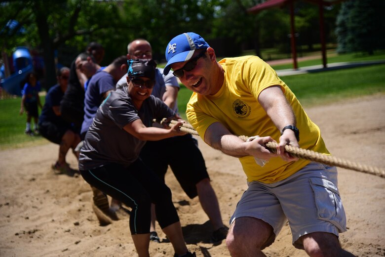 PETERSON AIR FORCE BASE, Colo. – Col. Douglas Scheiss, 21st Space Wing commander, and Chief Master Sgt. Idalia Peele, 21st Space Wing command chief, dig in during the tug-o-war competition at the annual Sports and Field Day at Peterson Air Force Base, Colo., June 16, 2016. The 27 different events were scattered throughout the base and lasted until 2 p.m. (U.S. Air Force photo by Staff Sgt. Amber Grimm)