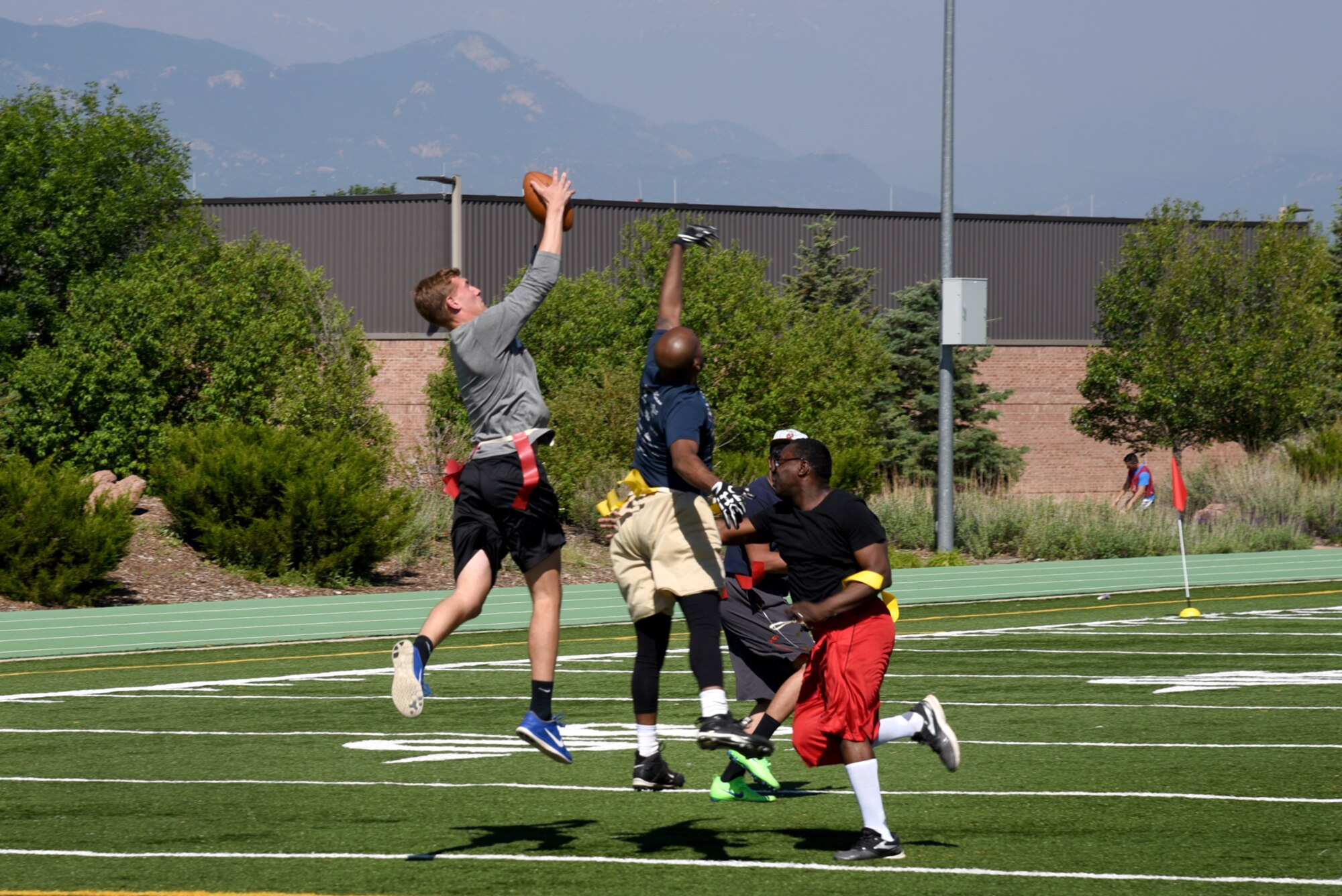 PETERSON AIR FORCE BASE, Colo. – Airmen battle for first down during a flag football match-up for the annual Sports and Field Day at Peterson Air Force Base, Colo., June 16, 2016. Events began at 8 a.m. and were scattered throughout the day, ending at 2 p.m. (U.S. Air Force photo by Airman 1st Class Dennis Hoffman)