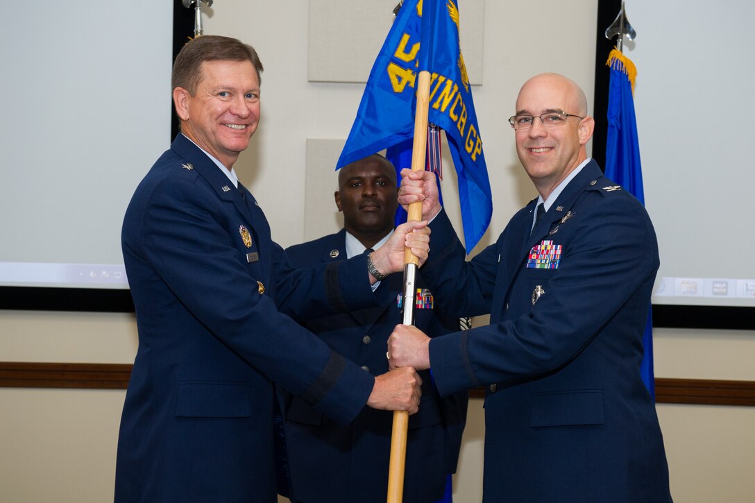 Brig. Gen. Wayne Monteith, 45th Space Wing commander, presents Col. Steven Lang, 45th Launch Group commander, with the guidon during a change of command ceremony June 21, 2016, at Patrick Air Force Base, Fla. Changes of command are a military tradition representing the transfer of responsibilities from the presiding officials to the upcoming official. (U.S. Air Force photo/Benjamin Thacker/Released) 