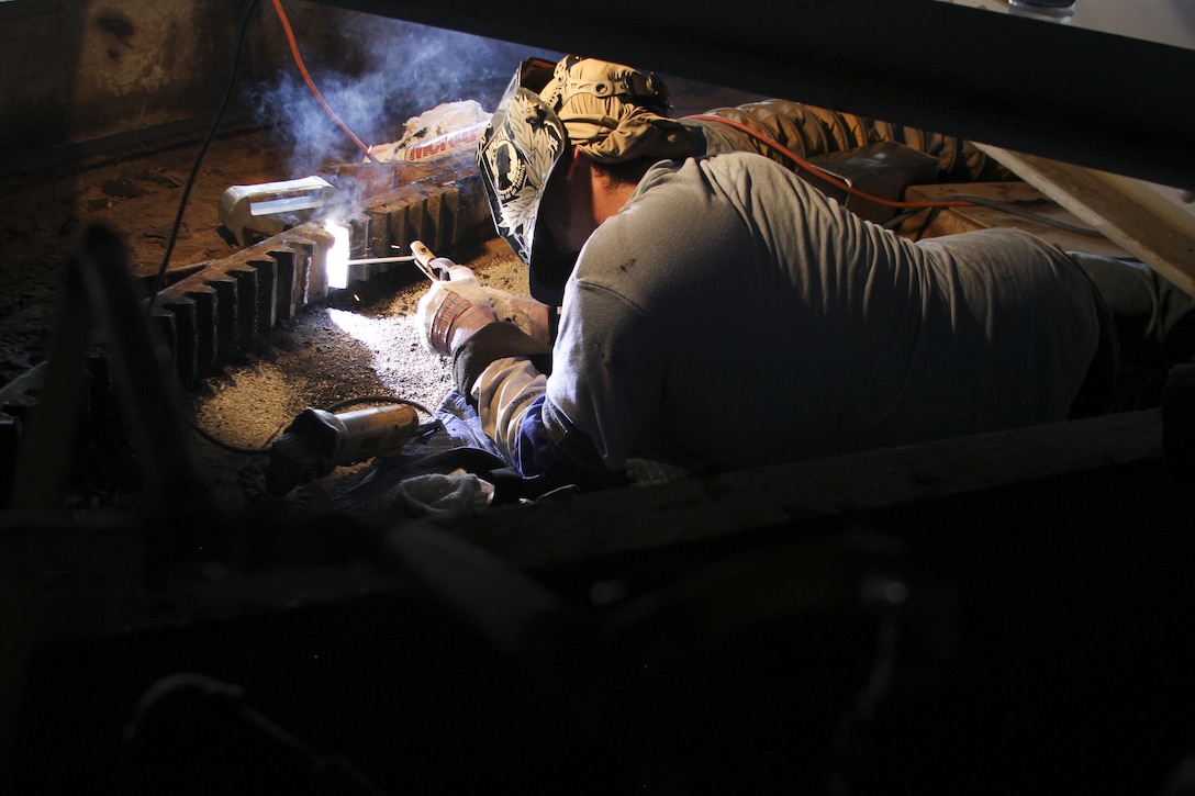 Christopher West, a welder with Norfolk Machine and Welding Inc., contracted by the Norfolk District, U.S. Army Corps of Engineers, works on repairing damaged gear teeth on the North Landing Bridge here, June 21, 2016. The repairs were needed to fix damage caused by a barge striking the bridge on June 4. (U.S. Army photo/Patrick Bloodgood)