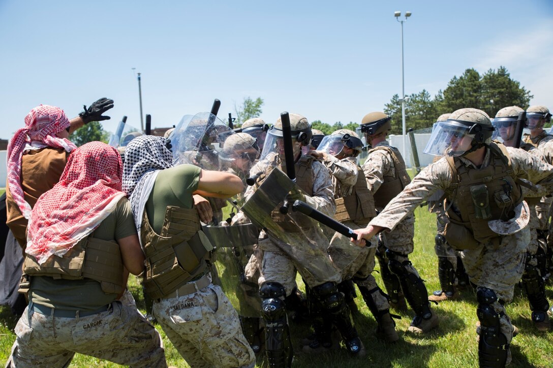 Marines with 4th Law Enforcement Battalion, Force Headquarters Group, Marine Forces Reserve, use crowd and riot control methods to fight off a group of enemy forces at the Muscatatuck Urban Training Center in Butlerville, Ind., June 9, 2016. The Marines focused on non-lethal techniques that could be used to defeat the enemy and accomplish the mission. (U.S. Marine Corps photo by Lance Cpl. Melissa Martens/ Released)