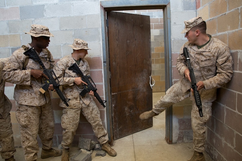 Marines with 4th Law Enforcement Battalion, Force Headquarters Group, Marine Forces Reserve, kick in a door during room clearing training at the Muscatatuck Urban Training Center in Butlerville, Ind., June 9, 2016. The Marines worked in teams to effectively search different rooms and apprehend any enemy forces they encountered.  (U.S. Marine Corps photo by Lance Cpl. Melissa Martens/ Released)