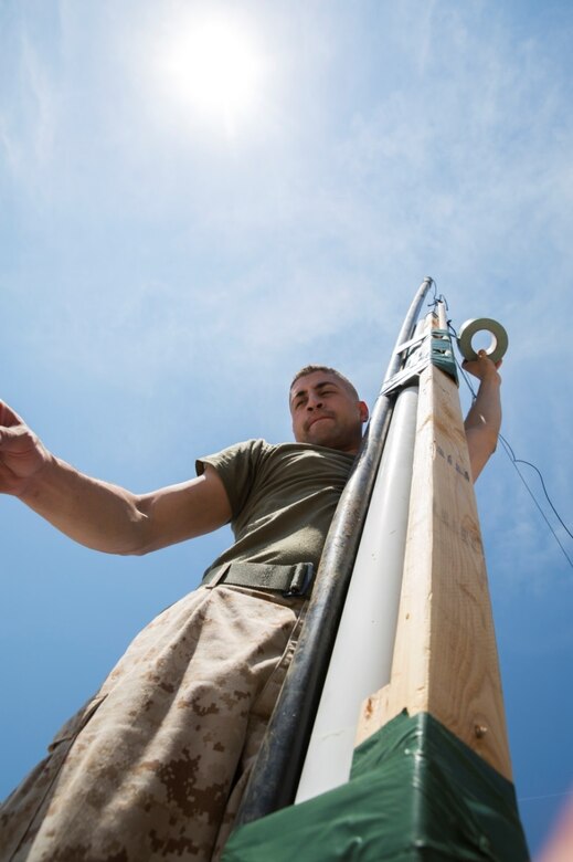 Cpl. Giovanni R. Mongy, a radio operator with 6th Communications Battalion, Force Headquarters Group, Marine Forces Reserve, sets up a field expedient antenna on the roof at the Muscatatuck Urban Training Center in Butlerville, Ind., June 10, 2016. The antenna allows Marines to utilize high frequency communication with other Marines in other areas of the country, such as Quantico, Virginia. (U.S. Marine Corps photo by Lance Cpl. Melissa Martens/ Released)