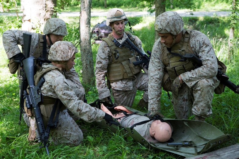 Marines with 3rd, 4th and 6th Air Naval Gunfire Liaison Company, Force Headquarters Group, Marine Forces Reserve, run through a litter course during ANGLICO Basic Course Training at Camp Atterbury, Ind., June 13, 2016. The Marines took contact from enemy forces while clearing a building, which left them with a casualty. They had to complete a course full of obstacles while bringing the causality to the safety helicopter.  (U.S. Marine Corps photo by Lance Cpl. Melissa Martens/ Released