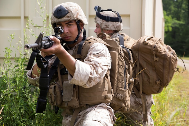 Lance Cpl. Bernardo D. Ibarra (front), a field radio operator with 3rd Air Naval Gunfire Liaison Company, Force Headquarters Group, Marine Forces Reserve, provides cover for his fellow Marines during training on a Military Operations Urban Terrain town at Camp Atterbury, Ind., June 15, 2016. The Marines took contact from enemy forces while clearing buildings, searching for improvised explosive devices and aiding to any casualties. (U.S. Marine Corps photo by Lance Cpl. Melissa Martens/ Released) 