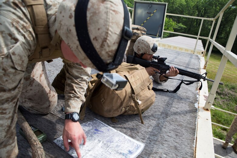 Lance Cpl. Dalton J. Vandervoort (front), a fire support-man with 4th Air Naval Gunfire Liaison Company, Force Headquarters Group, Marine Forces Reserve, establishes a grid for immediate suppression during training on a Military Operations Urban Terrain town at Camp Atterbury, Ind., June 15, 2016. The Marines took contact from enemy forces while clearing buildings, searching for improvised explosive devices and aiding to any casualties. (U.S. Marine Corps photo by Lance Cpl. Melissa Martens/ Released)