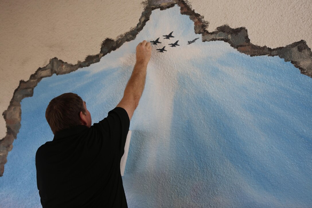Artist Richard DeRosset, a La Jolla, Calif., native and a Navy veteran, cleans off a portion of the mural he painted for the Airmen and Marine Memorial Chapel aboard Marine Corps Air Station Miramar, Calif., May 10. DeRosset painted the mural as a part of the War on Terrorism Memorial at the chapel. (U.S. Marine Corps photo by Pfc. Liah Kitchen/Released)