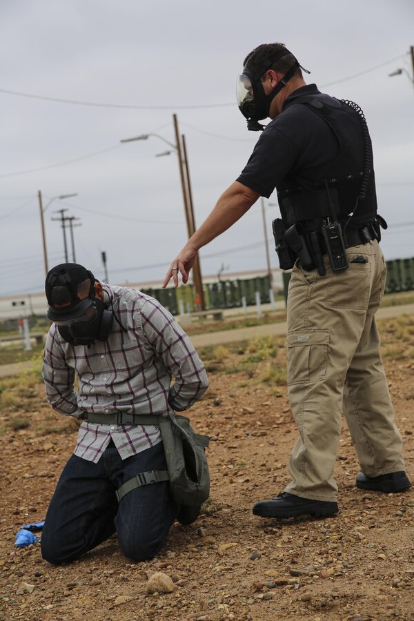 A civilian law enforcement officer with the Provost Marshal’s Office apprehends a suspect during a Chemical, Biological, Radiological, Nuclear and High-Yield Explosives (CBRNE) exercise at the gas chamber aboard Marine Corps Air Station Miramar, Calif., May 18. The exercise revolved around PMO, the Miramar Fire Department, Explosive Ordnance Disposal, and Aircraft Rescue and Firefighting working together to identify and eliminate the threat of a simulated clandestine drug lab. (U.S. Marine Corps photo by Cpl. Alissa Schuning/Released)
