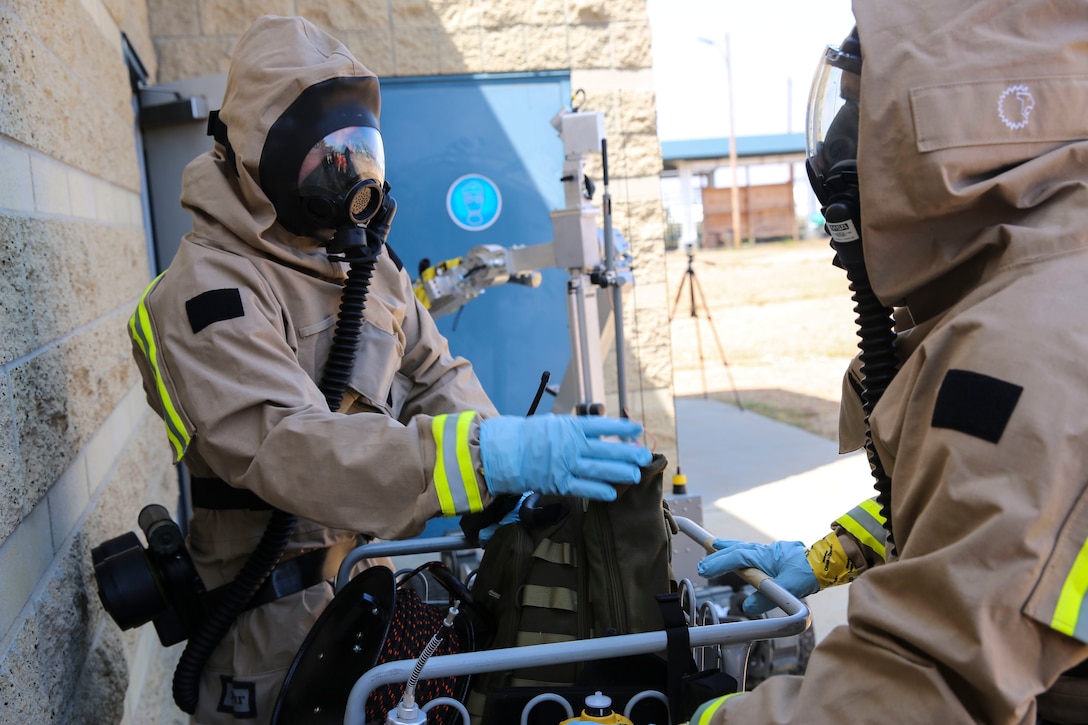 Marines with Explosive Ordnance Disposal gather their gear before entering the hazardous area during a Chemical, Biological, Radiological, Nuclear and High-Yield Explosives (CBRNE) exercise at the gas chamber aboard Marine Corps Air Station Miramar, Calif., May 18. The exercise revolved around PMO, the Miramar Fire Department, Explosive Ordnance Disposal, and Aircraft Rescue and Firefighting working together to identify and eliminate the threat of a simulated clandestine drug lab. (U.S. Marine Corps photo by Cpl. Alissa Schuning/Released)