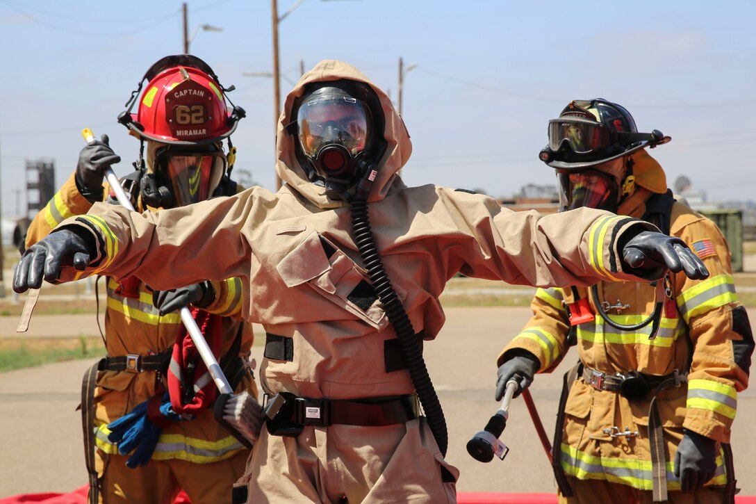 Firefighters with the Marine Corps Air Station Miramar Fire Department decontaminate a Marine with Explosive Ordnance Disposal after he entered the contaminated area during a Chemical, Biological, Radiological, Nuclear and High-Yield Explosives (CBRNE) exercise at the gas chamber aboard Marine Corps Air Station Miramar, Calif., May 19. The exercise revolved around PMO, the Miramar Fire Department, Explosive Ordnance Disposal, and Aircraft Rescue and Firefighting working together to identify and eliminate the threat of a simulated clandestine drug lab. (U.S. Marine Corps photo by Cpl. Alissa Schuning/Released)