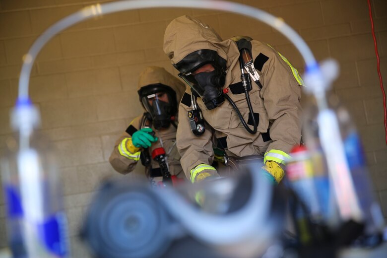 Marines with the Aircraft Rescue and Firefighting hazardous material team assess the contaminated area during a Chemical, Biological, Radiological, Nuclear and High-Yield Explosives (CBRNE) exercise at the gas chamber aboard Marine Corps Air Station Miramar, Calif., May 18. The exercise revolved around PMO, the Miramar Fire Department, Explosive Ordnance Disposal, and Aircraft Rescue and Firefighting working together to identify and eliminate the threat of a simulated clandestine drug lab. (U.S. Marine Corps photo by Cpl. Alissa Schuning/Released)