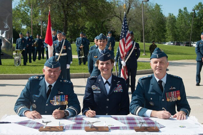 Incoming 1 Canadian Air Division commander MGen. Christian Drouin (left), NORAD and USNORTHCOM commander, Gen. Lori Robinson (center), and outgoing 1 CAD commander MGen. David Wheeler (right), sign the Change of Command scrolls during the 1 CAD Change of Command ceremony at Winnipeg, Manitoba, Canada, June 21, 2016.

As Commander of 1 CAD, Major-General Drouin also assumes command of the Canadian NORAD Region and the Joint Forces Air Component Command for the Canadian Joint Operations Command.
(Photo by Cpl Paul Shapka)