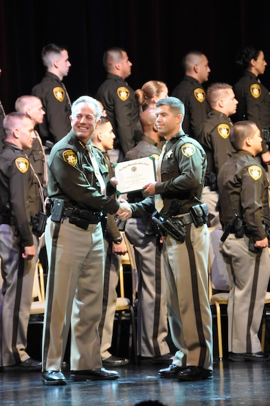 (Right) Tech. Sgt. Jonathan Carrington, 926th Aircraft Maintenance Squadron, receives his certificate from Sheriff Joseph Lombardo, during the Las Vegas Metropolitan Police Department's academy graduation ceremony June 14. Carrington is an F-16 weapons loader in the Air Force Reserve. (U.S. Air Force photo/Maj. Jessica D'Ambrosio)