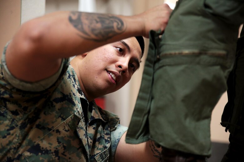 U.S. Marine Corps Cpl. Harley Damarputra, an aviation life-support equipment technician and collateral duty inspector with Marine Fighter Attack Squadron (VMFA) 314, stationed at Marine Corps Air Station Miramar, California, forward deployed to MCAS Iwakuni, Japan, adjusts the calf on an anti-g suit for a pilot during exercise Red Flag-Alaska 16-2 at Eielson Air Force Base, Alaska, June 16, 2016. Damarputra supports the squadron as a life-support equipment technician and collateral duty inspector by ensuring the pilots’ safety gear is working properly. (U.S. Marine Corps photo Lance Cpl. Donato Maffin/Released) 