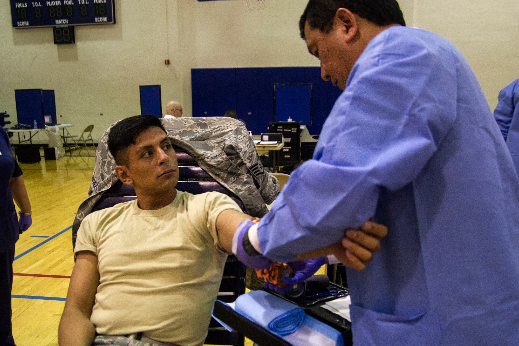 Taib Dipatuan, Walter Reed National Medical Center phlebotomist, puts a bandage on Staff Sgt. Oscar Chavez, 779th Medical Operations Squadron NCO in charge of outreach, following Chavez’s donation of one pint of blood, in the East Fitness Center on Joint Base Andrews, Md., June 16, 2016. The 11th Logistics Readiness Squadron, in conjunction with ASBP, collected blood donations that will be shipped into theater and to local medical treatment facilities around the National Capitol Region. (U.S. Air Force photo by Airman Gabrielle Spalding)