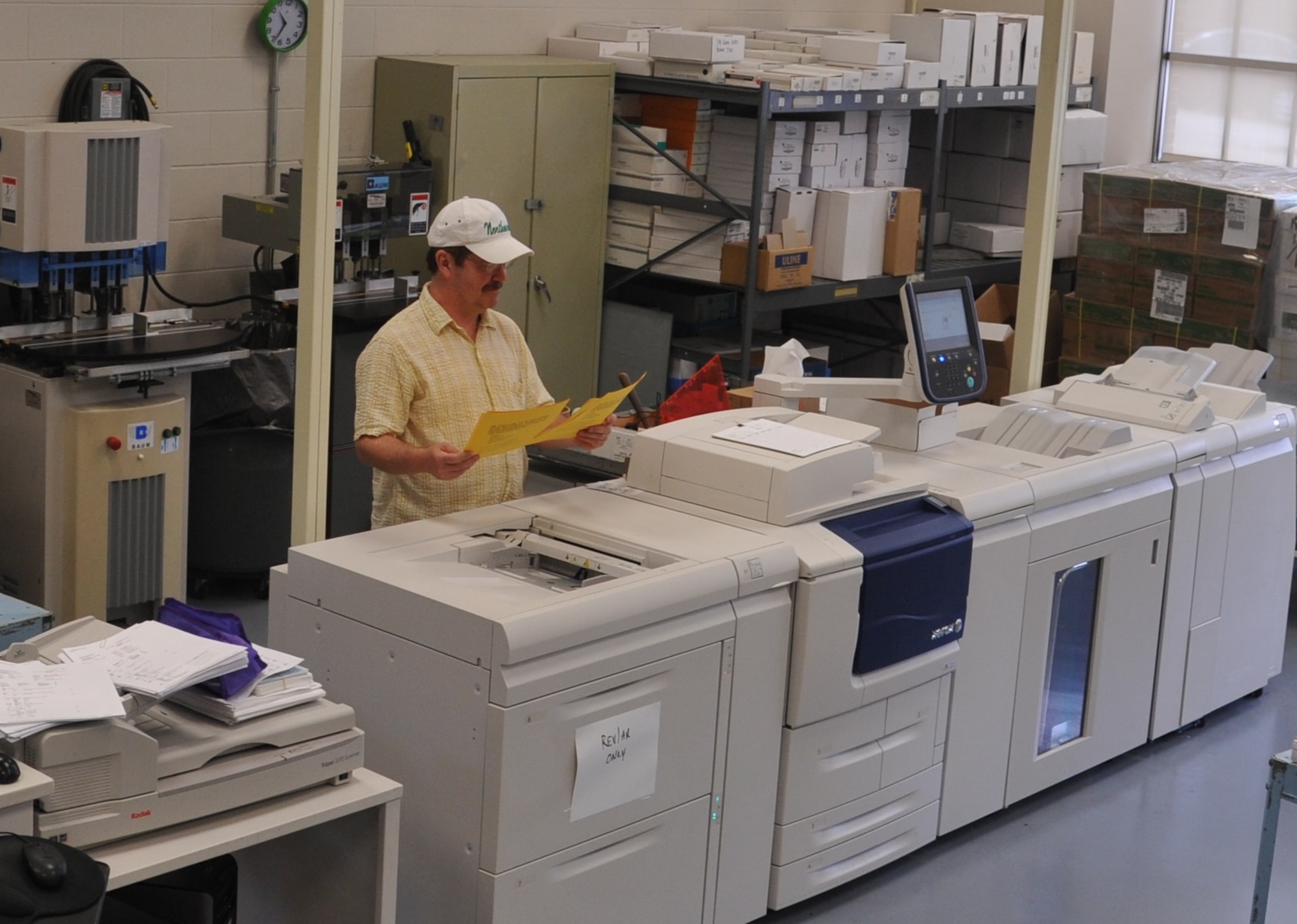 Timothy Pillion, DLA Document Services team lead, uses up-to-date equipment to check print quality to ensure product meets customer standards.  (U.S. Air Force photo/Sandy Simison)