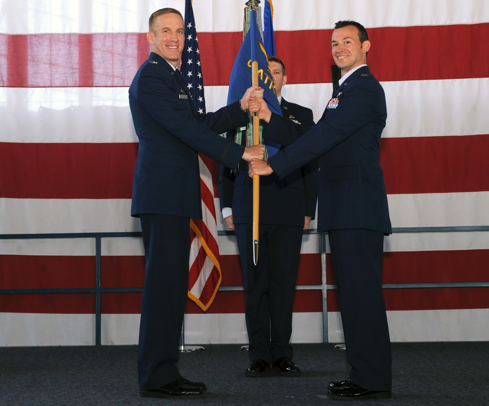Col. Case Cunningham, 432nd Wing commander, left, hands the guidon for the 89th Attack Squadron to Lt. Col. Albert, 89th ATKS commander, during a redesignation ceremony at Ellsworth Air Force Base, S.D., June 21, 2016. With the 28th Bomb Wing being realigned under Air Force Global Strike Command from Air Combat Command in October 2015, the 432nd ATKS became a tenant unit at Ellsworth AFB and needed to be renamed. (U.S. Air Force photo by Airman 1st Class Denise M. Nevins/Released)