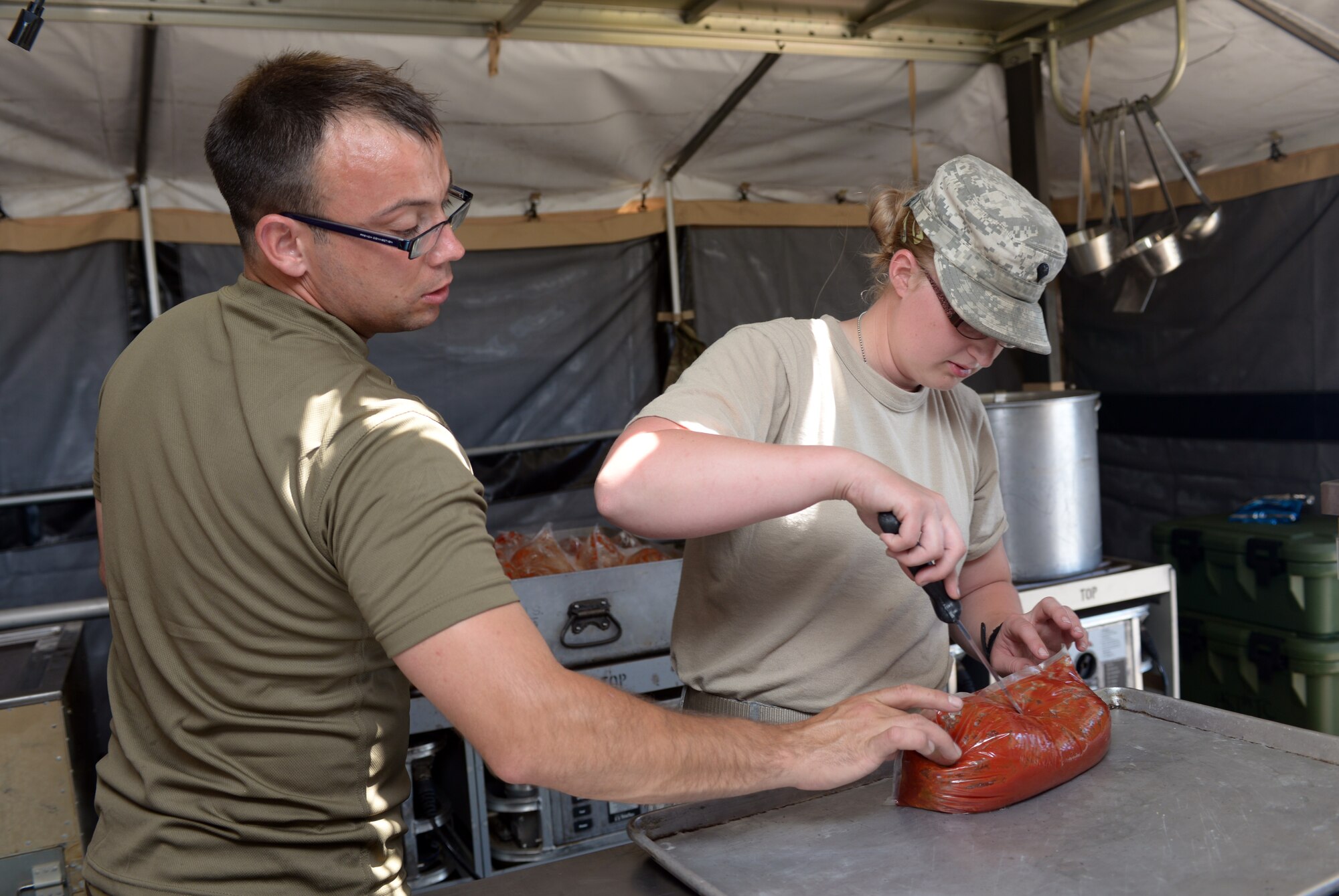 British Army Cpl. Paul Demarce, 154th Scottish Regiment Royal Logistics Corps and 230th Transport Squadron chef, and Ohio Army National Guard Spc. Carissa Bonham, 1487th Transportation Company food service specialist, prepare meatloaf during the 2016 Golden Coyote exercise at Ellsworth Air Force Base, S.D., June 15, 2016. During the exercise, food service specialists prepare food to keep the various companies of soldiers stationed at Camp Lancer on EAFB fit to fight. (U.S. Air Force photo by Airman Donald Knechtel/Released)