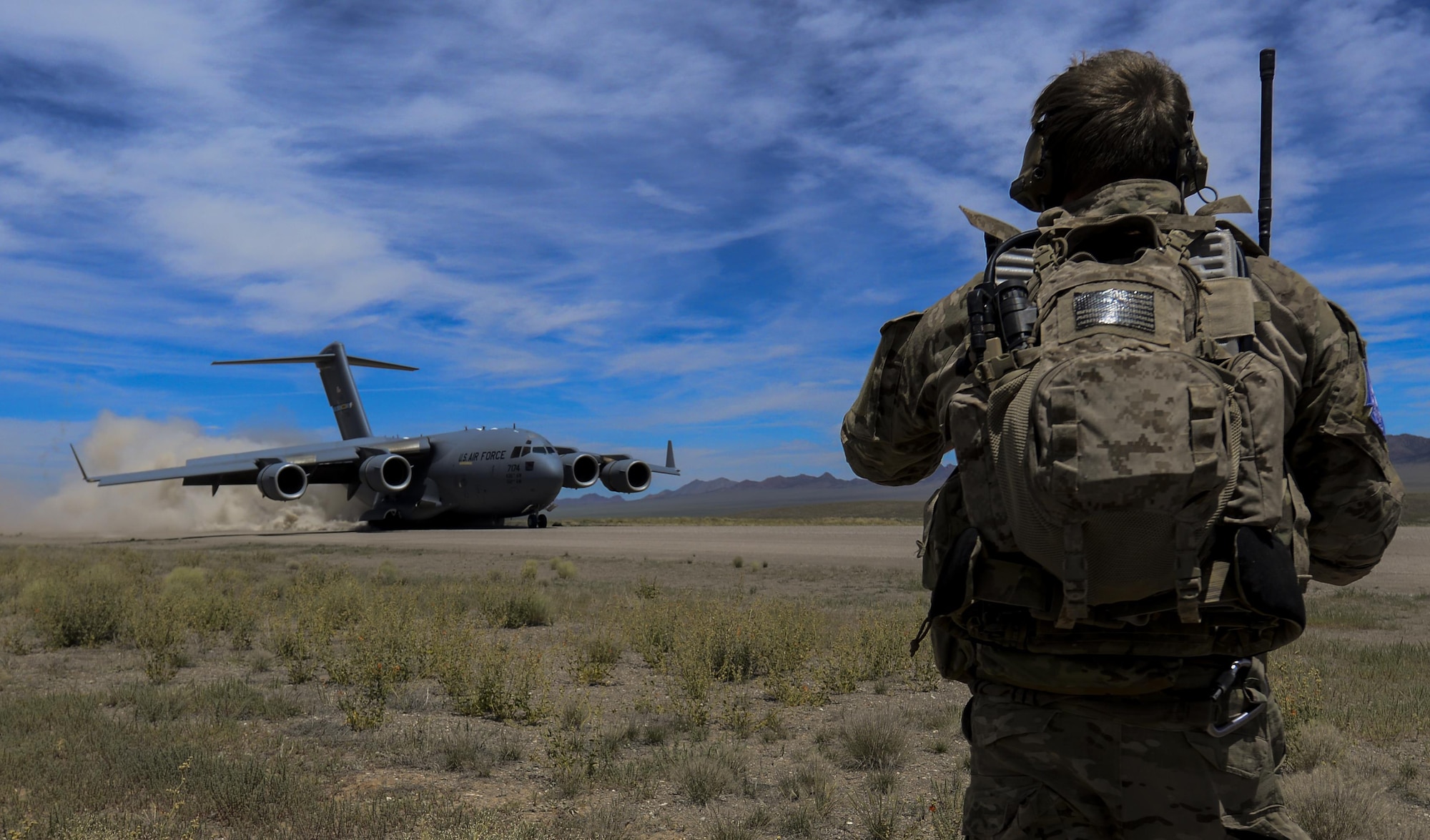 A Combat Controller watches as a C-17 assigned to the 17th Weapons Squadron, Nellis Air Force Base, Nevada, lands on an airstrip in the Nevada Test and Training Range during Joint Forcible Entry Exercise, June 16, 2016. The exercise demonstrates the Air Force’s ability to tactically deliver and recover combat forces via air drops and combat landings in a contested environment. (U.S. Air Force photo by Airman 1st Class Kevin Tanenbaum)